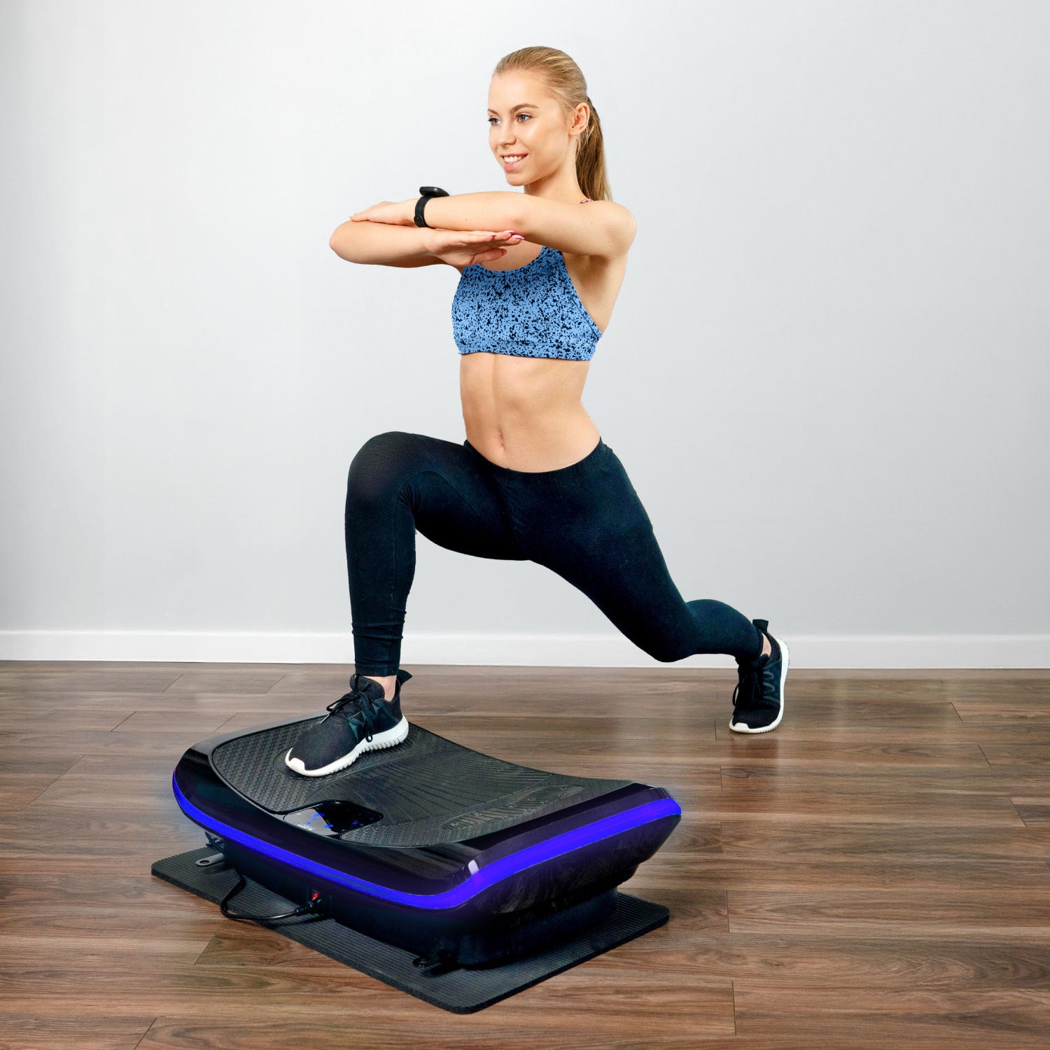 Woman in blue sports bra lunging on a fitness balance board with purple lights.